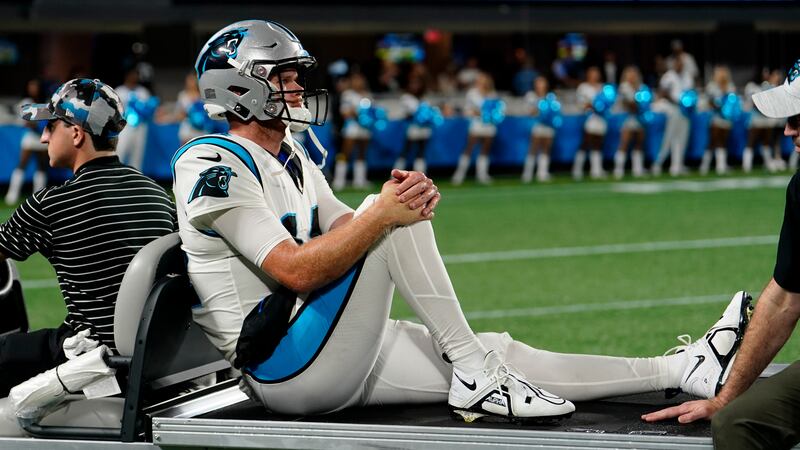 Carolina Panthers quarterback Sam Darnold leaves the field on a cart after getting injured...