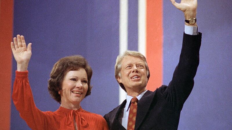 FILE - Jimmy Carter, right, and his wife, Rosalynn Carter, wave together at the National...