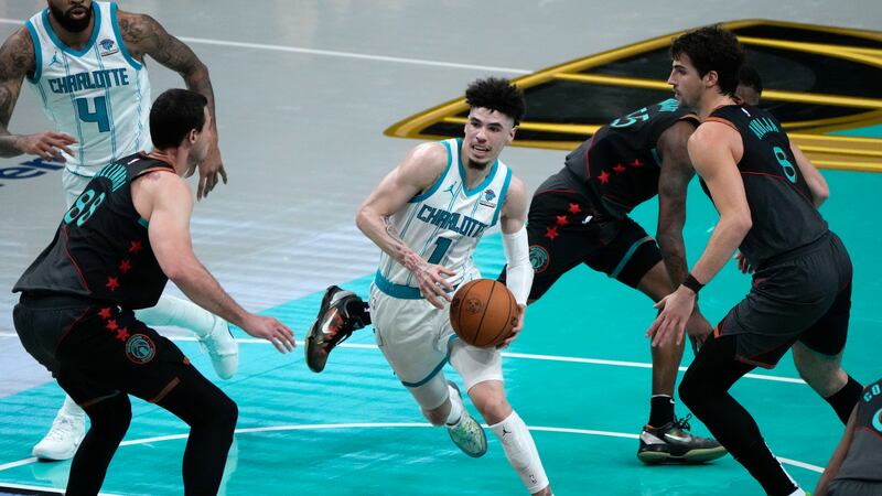 Charlotte Hornets guard LaMelo Ball (1) drives to the basket between Washington Wizards...