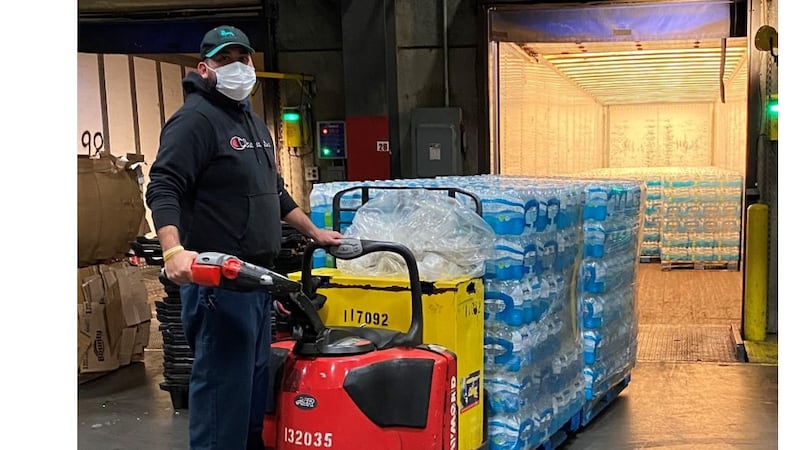 A worker loads bottled water into the trailer on Monday afternoon.